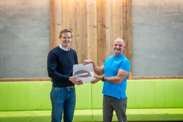 Florian Unterberger (links) und Roland Baumann (rechts) bei der Kuchenübergabe