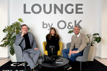 Thomas Oberhuber, Andrea Maria Hölbl und Armin Kuen (v.l.n.r.) präsentierend das Programm der O&K Academy – Foto im Querformat.
