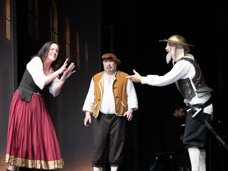 Szenenfoto aus dem Musical „Der Mann von La Mancha“ am Stadttheater Kufstein: Ensemble in einer kraftvollen Spielsituation zwischen Kerker und Fantasiewelt.